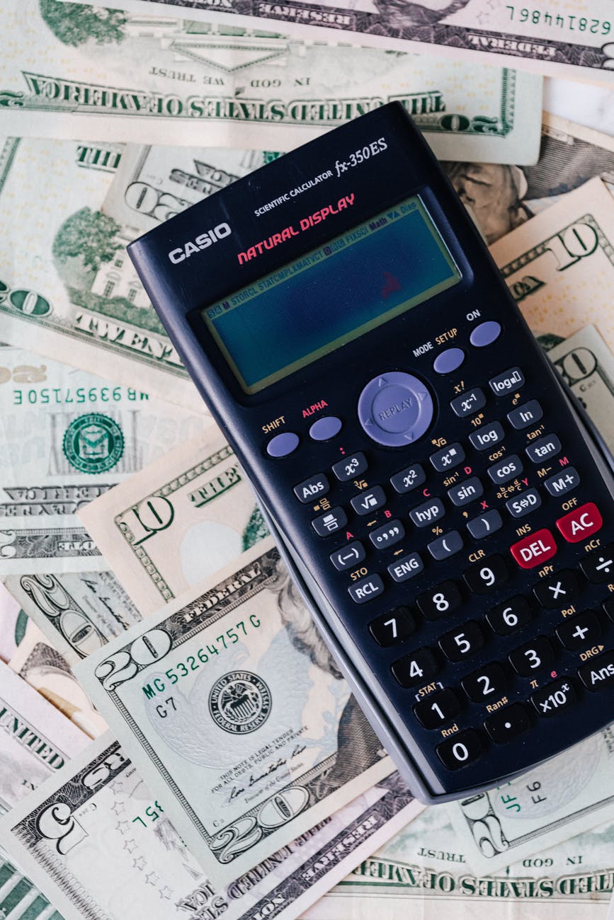 calculator placed over stack of usa dollars